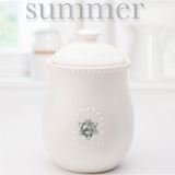 White Ceramic Canister w/Lid and  5 Interchangeable Metal Seasonal/Decor Magnets.